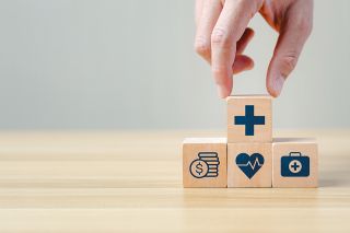 Foto: Hand legt einen Holzblock auf andere Blöcke